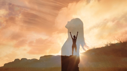 Woman,Celebrating,On,A,Mountain,Looking,Up,To,The,Sky.